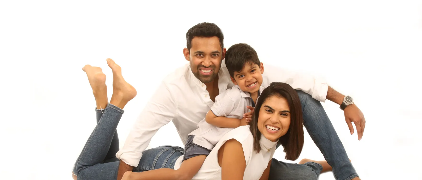 Parents and their young son lying together on the studio floor