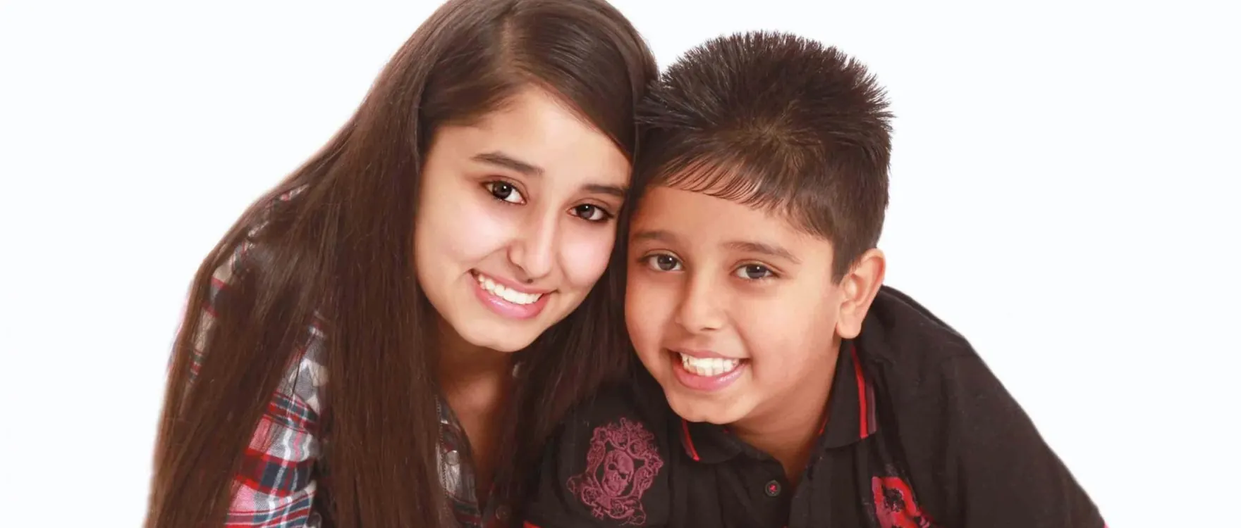Brother and sister lying side by side, studio portrait