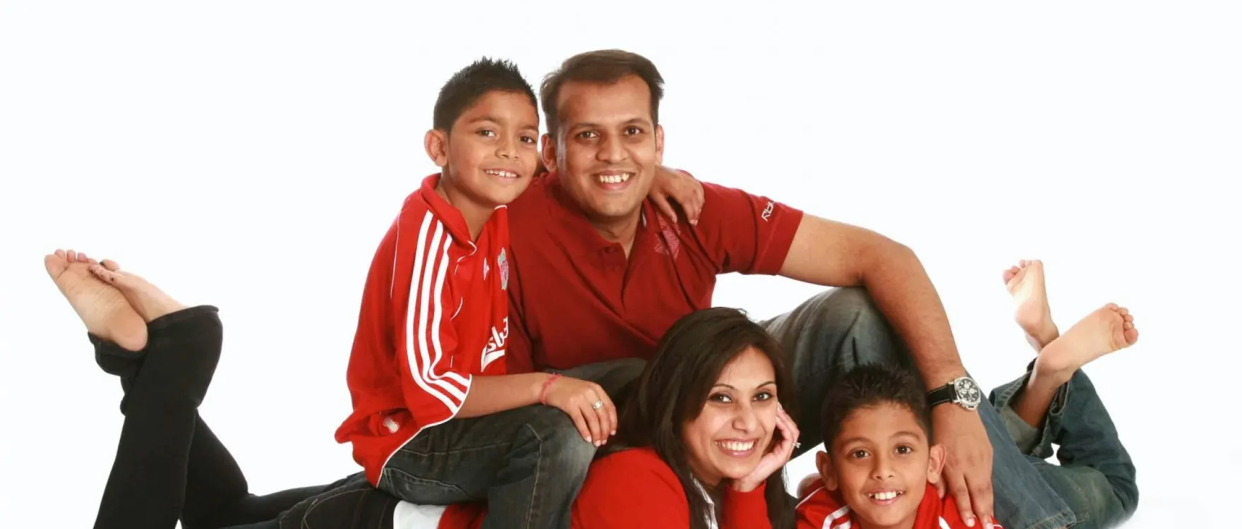 Family of four in red and black lying on the studio floor