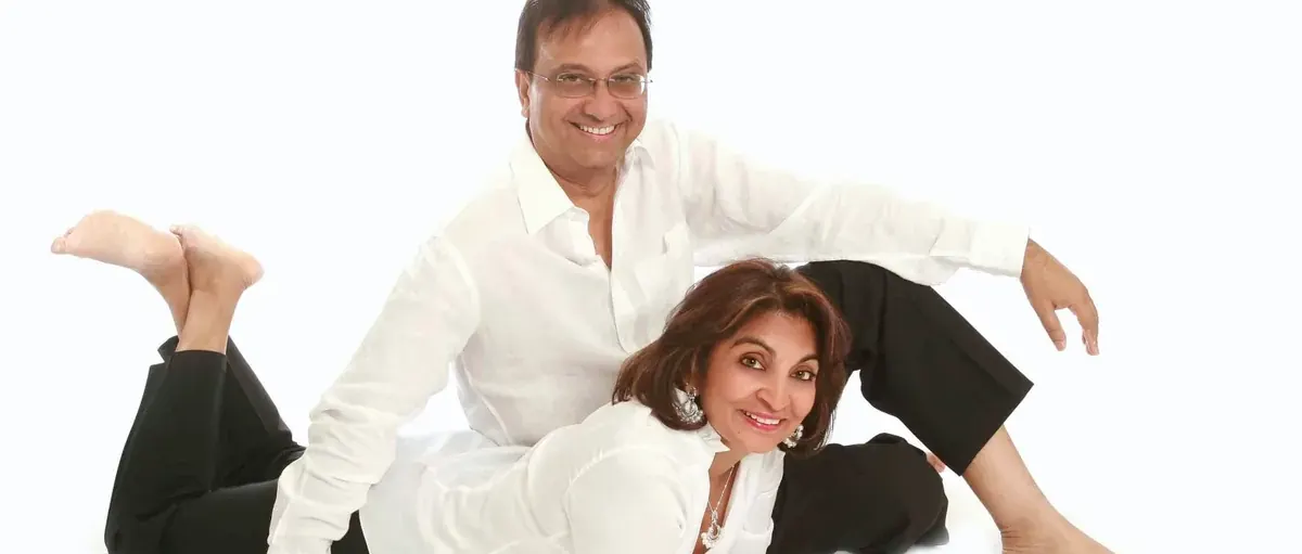 Couple in white shirts and black trousers lying on the studio floor